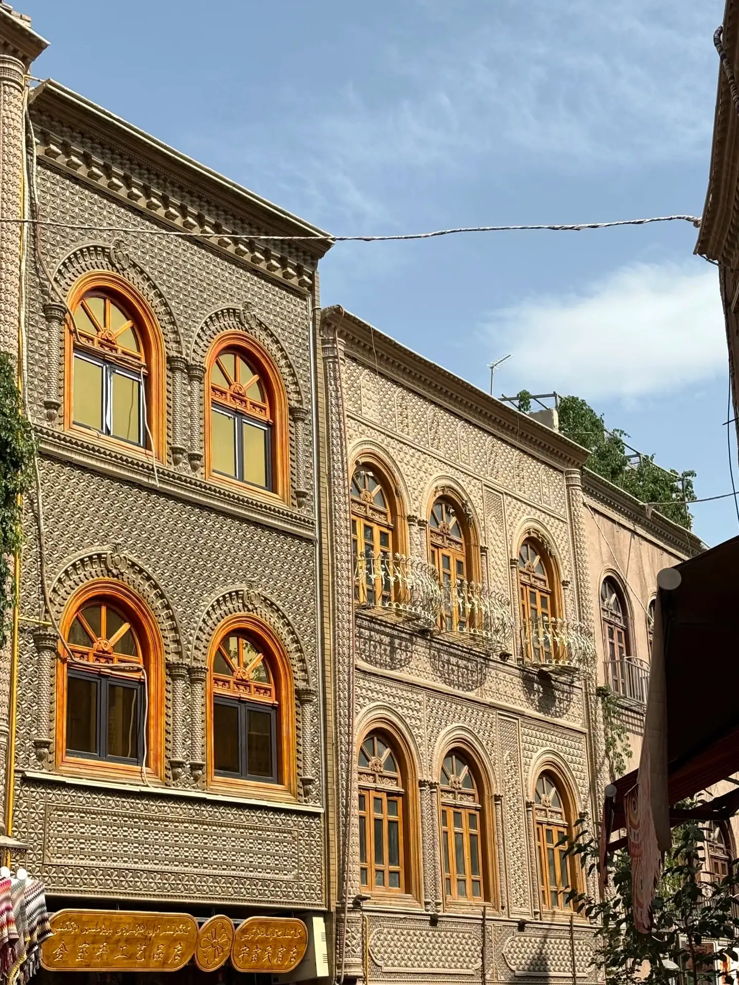 a row of arched, colorful windows set in a brick-walled building