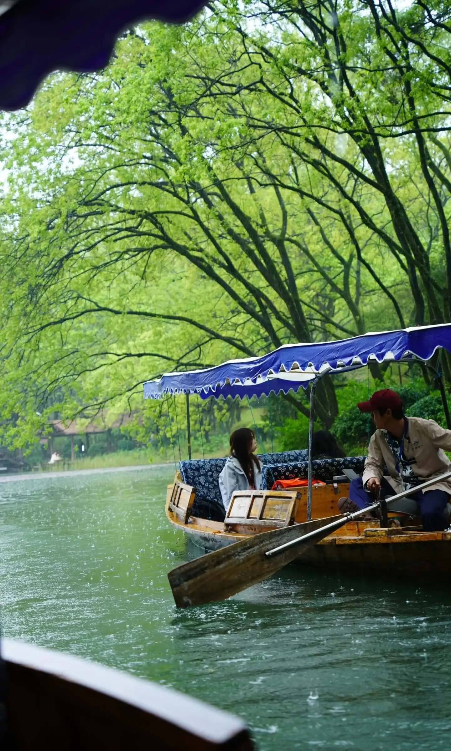 Hand-rowed boats on the West Lake waterways and a boatman in the distance