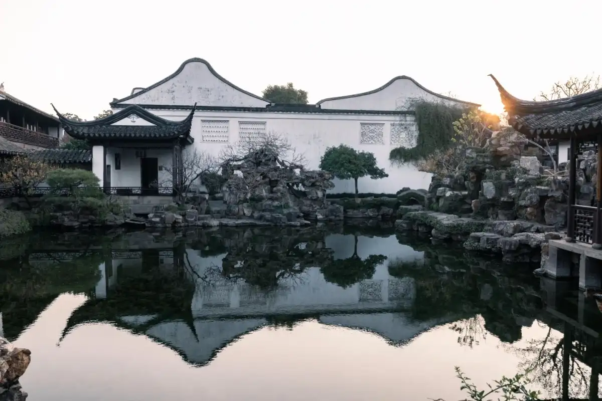 网师园白墙石岸与池水倒影