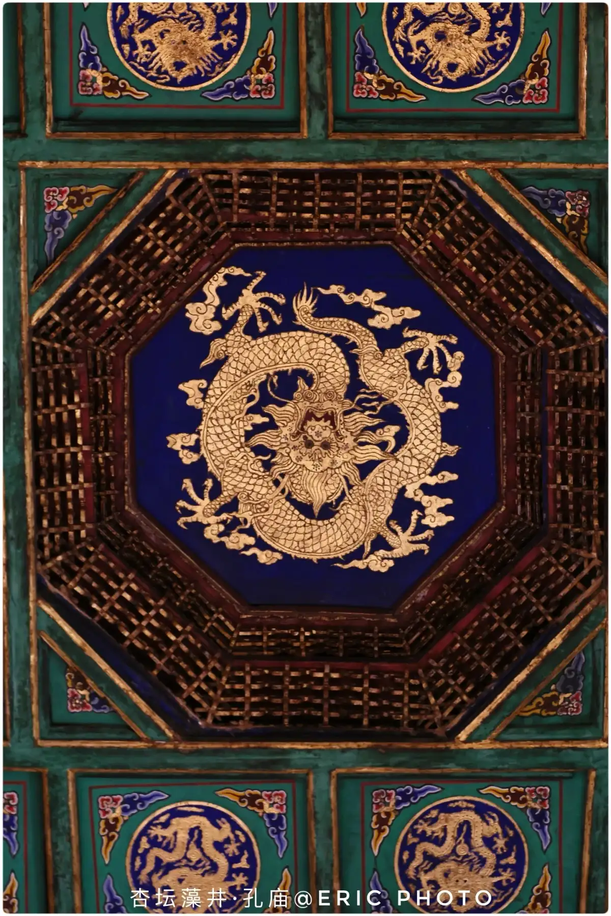 The golden dragon patterns in the octagonal coffered ceiling of the Xingtan Hall at the Confucius Temple and the surrounding square grid