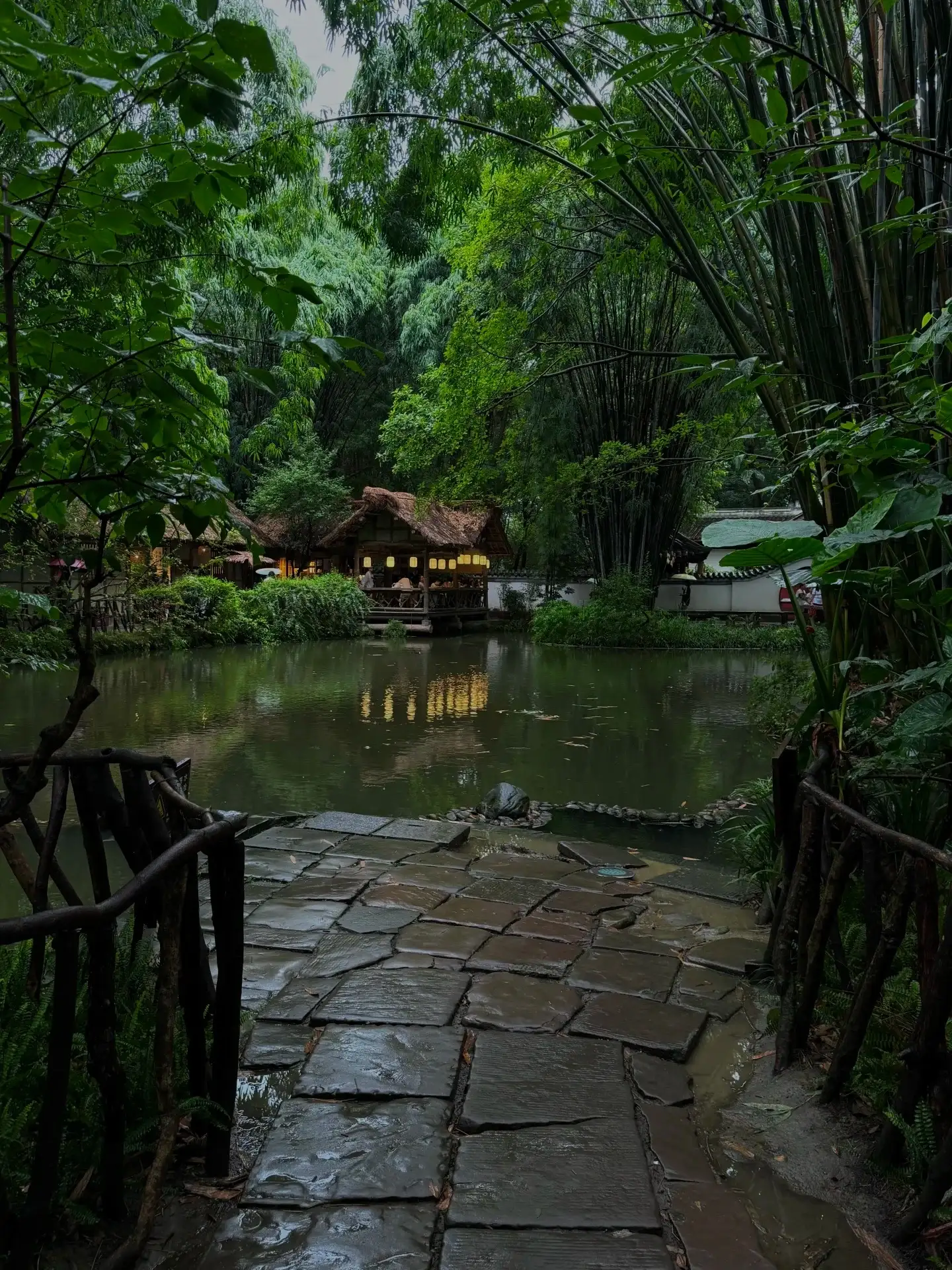 湿石板路通向池塘边的园林小亭