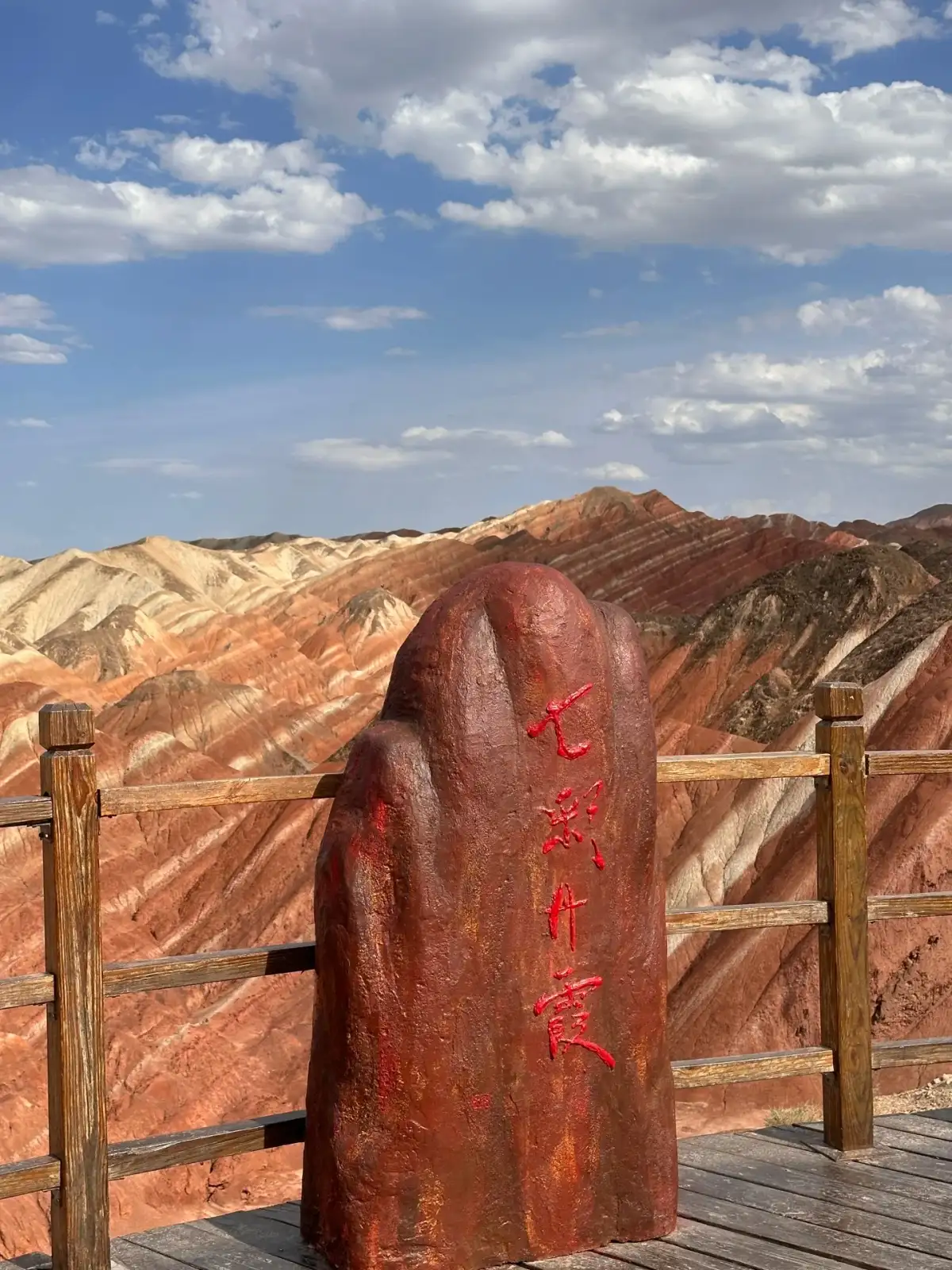 Signage at the Zhangye Seven-Color Danxia Viewing Platform and the surrounding mountains