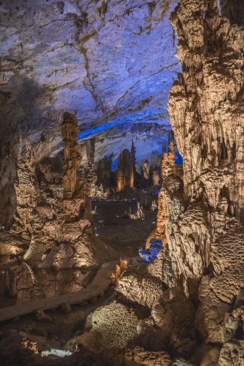 Blue cave ceiling lighting and dense cave deposits in the foreground
