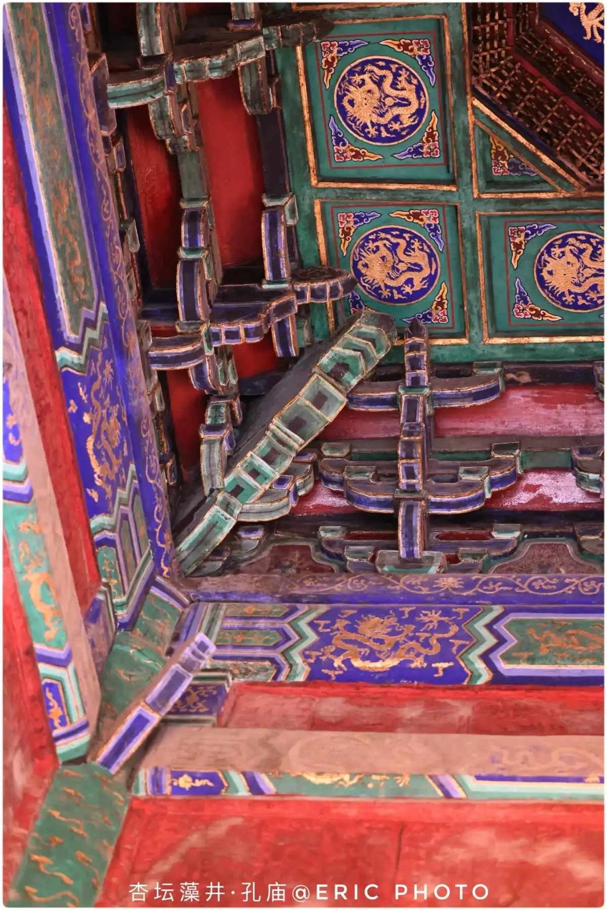 the painted beam framework, bracket sets, and the edge of the coffered ceiling above the Xingtan Platform
