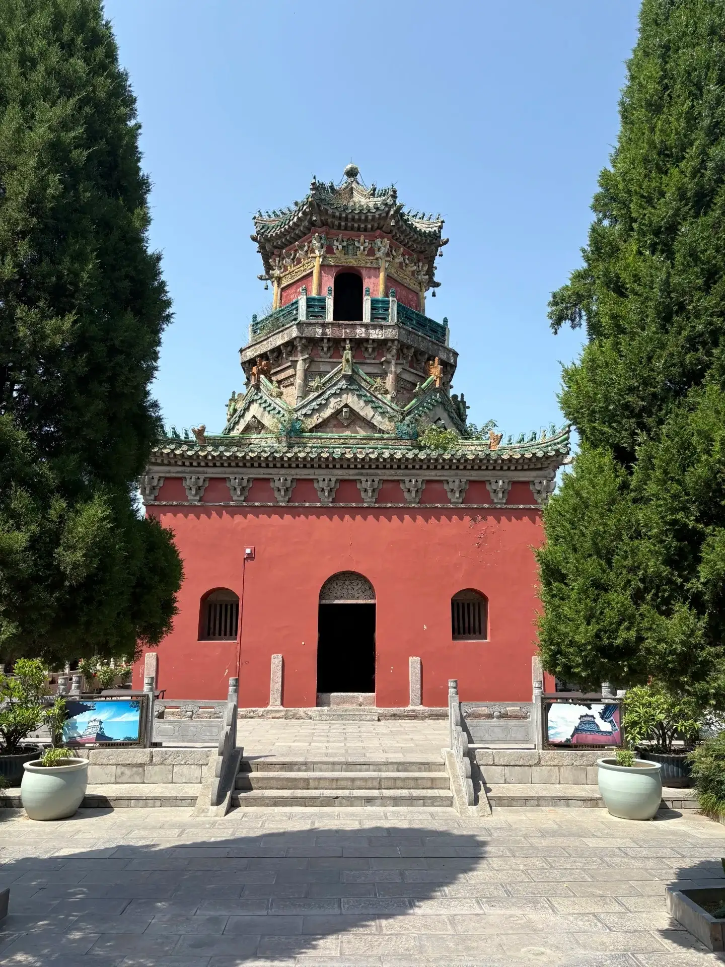 A multi-story, polychrome pavilion atop a red plinth