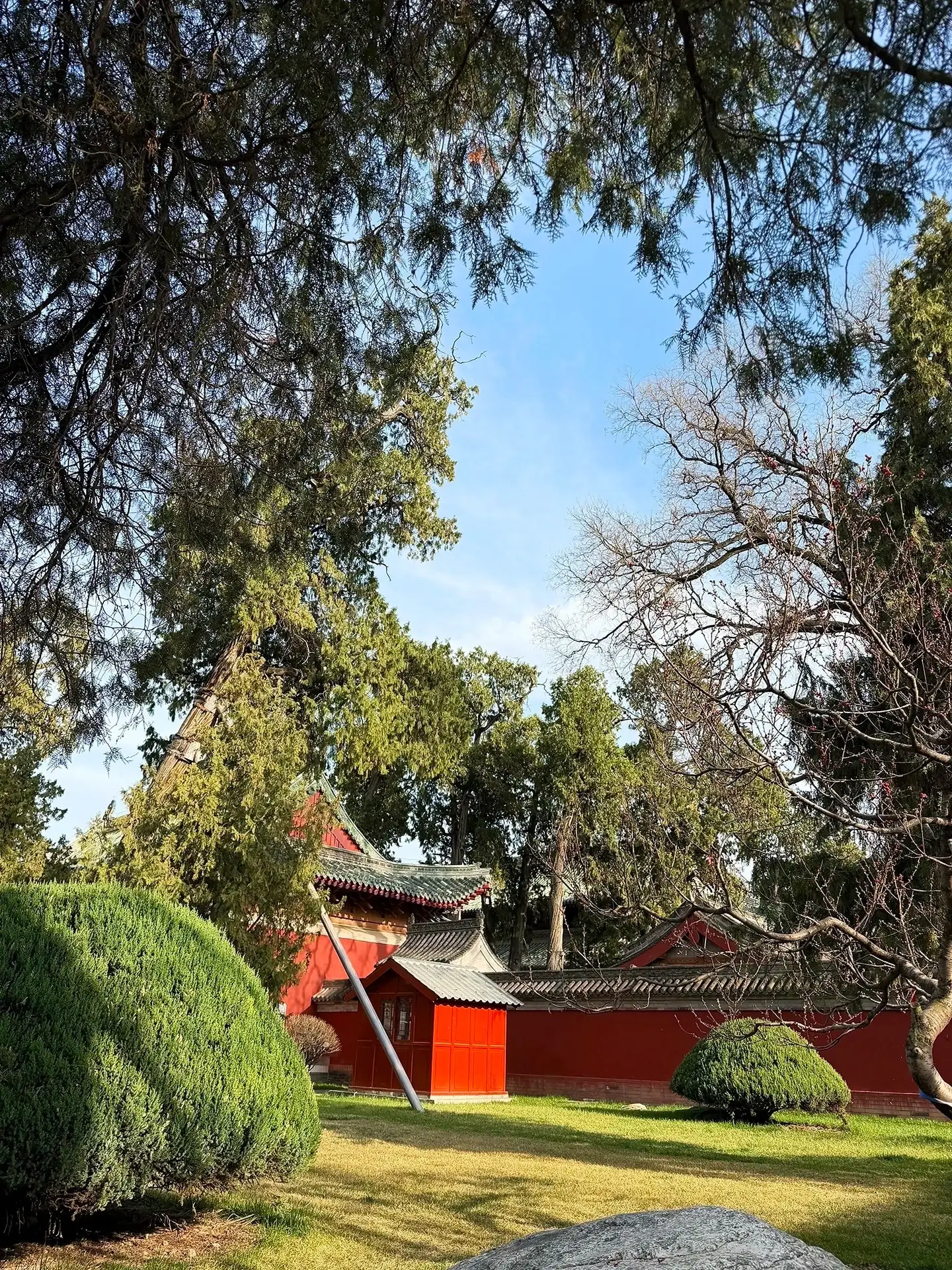 courtyard lawns, red walls, trees, and eaves