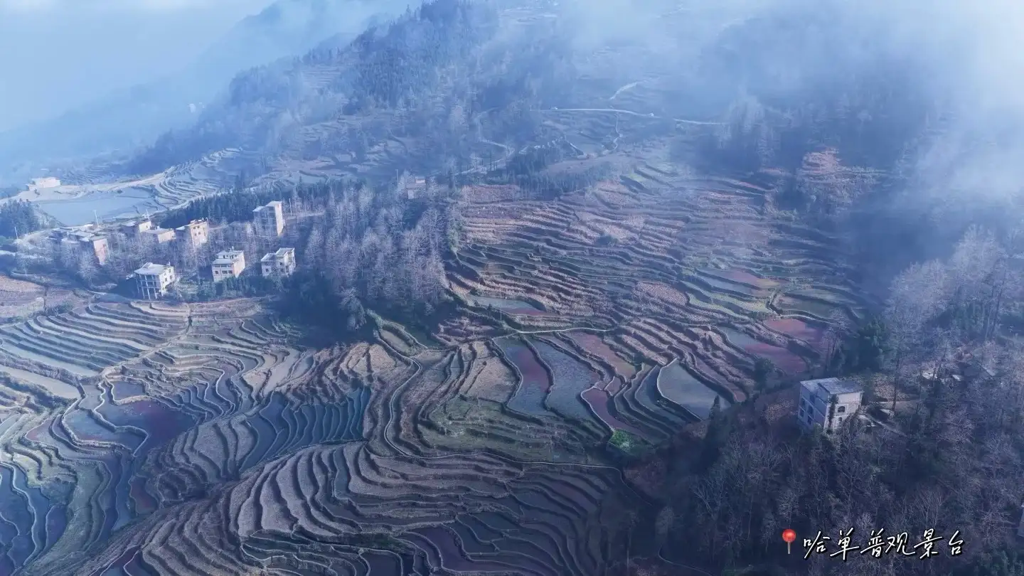 Terraced rice paddies cascading up the hillside and a village shrouded in mist; the image includes text describing the viewpoint.