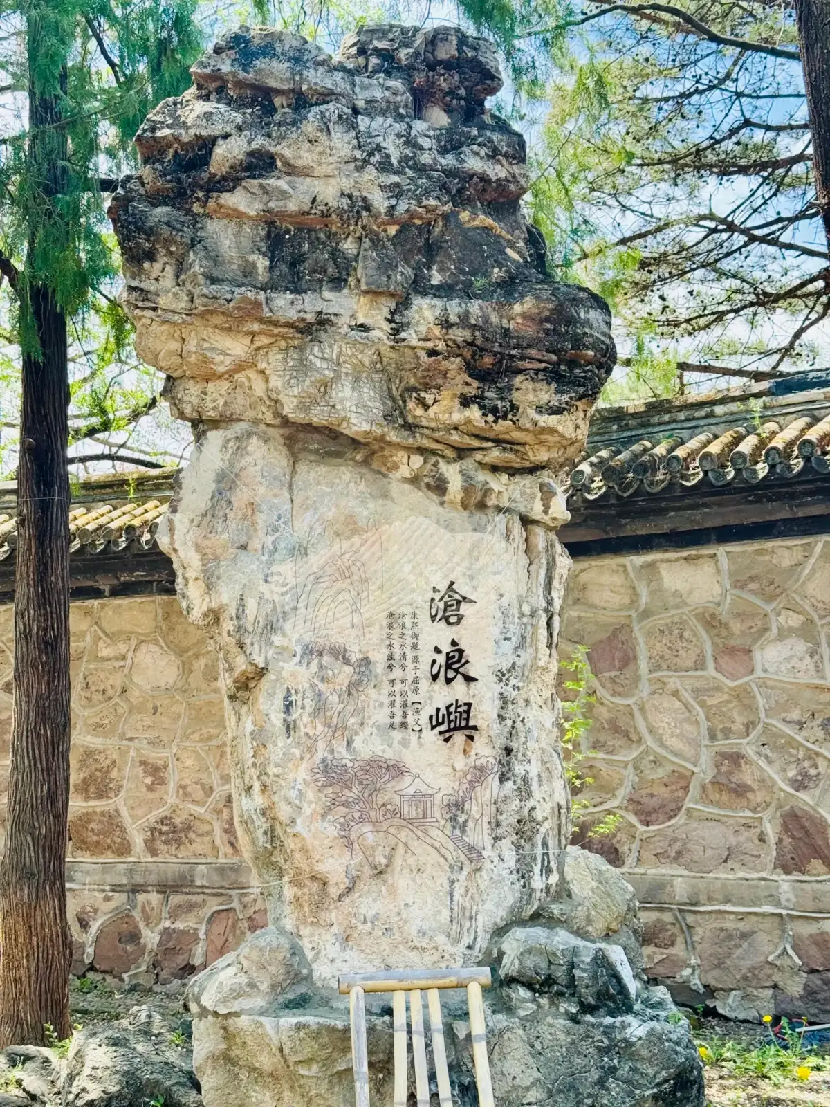A stone carving inscribed with the words “Canglangyu” and the garden wall