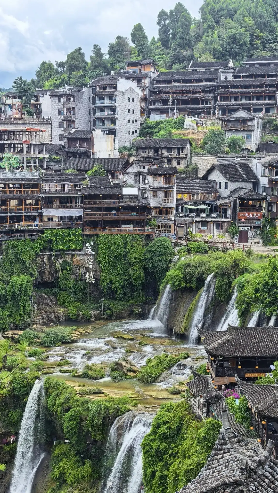 The waterfalls and waterside buildings of Furong Town during the day