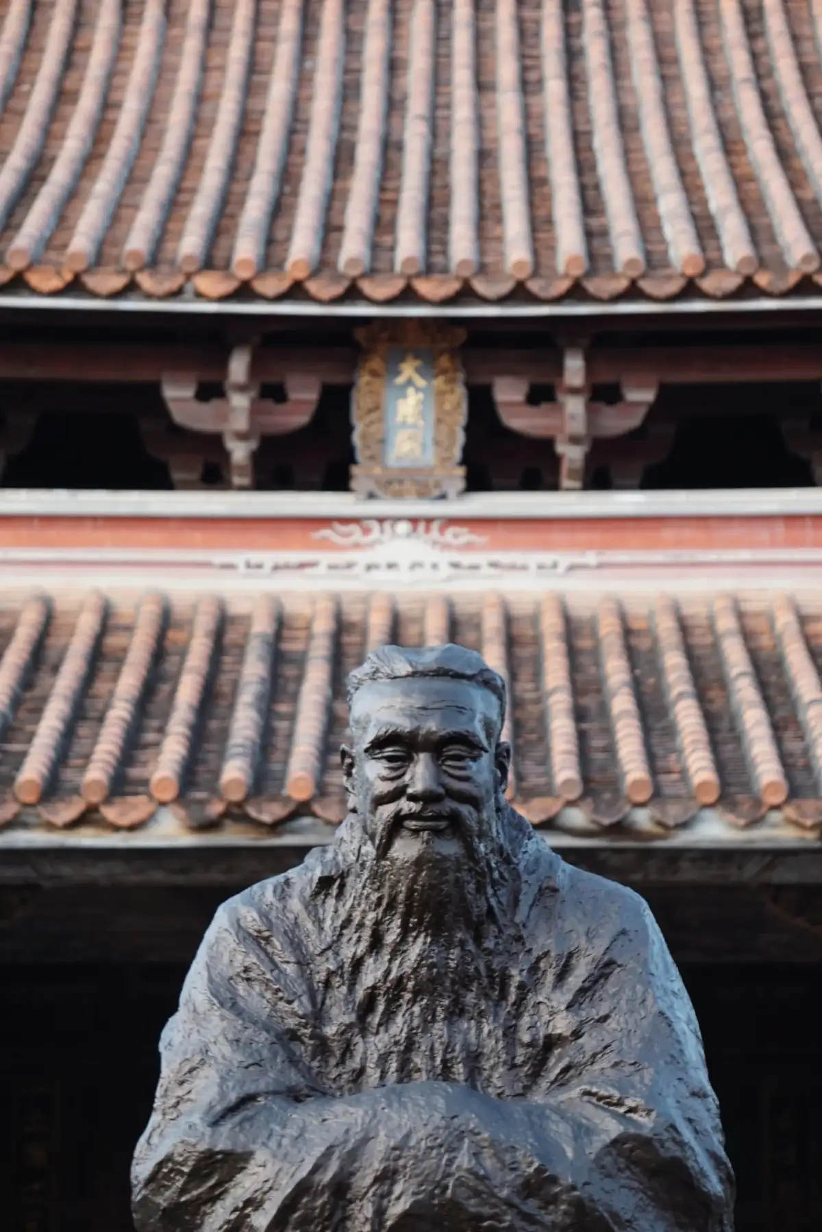 A statue of Confucius in front of the eaves of Zhangzhou’s Old City