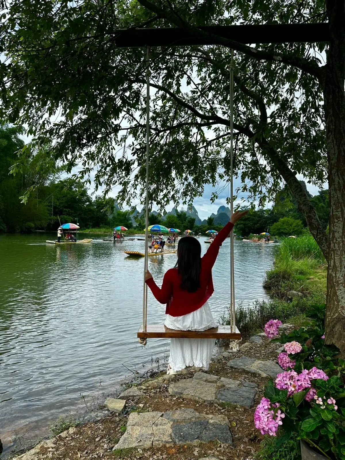 A tourist’s silhouette on a swing along the Yulong River
