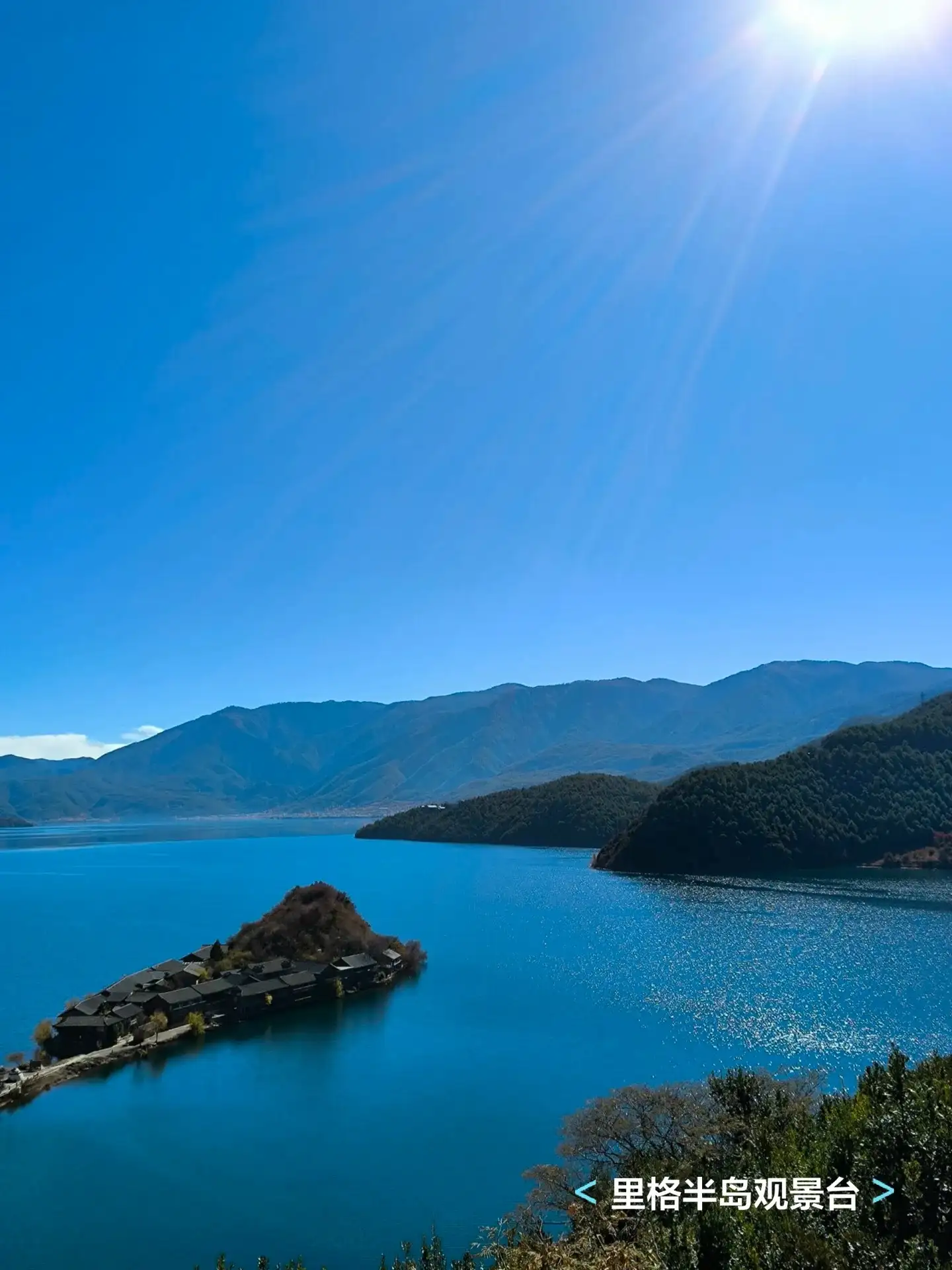 从高处俯看蓝色湖湾与伸入水中的半岛,远山围绕湖面,原图带有观景台标注。